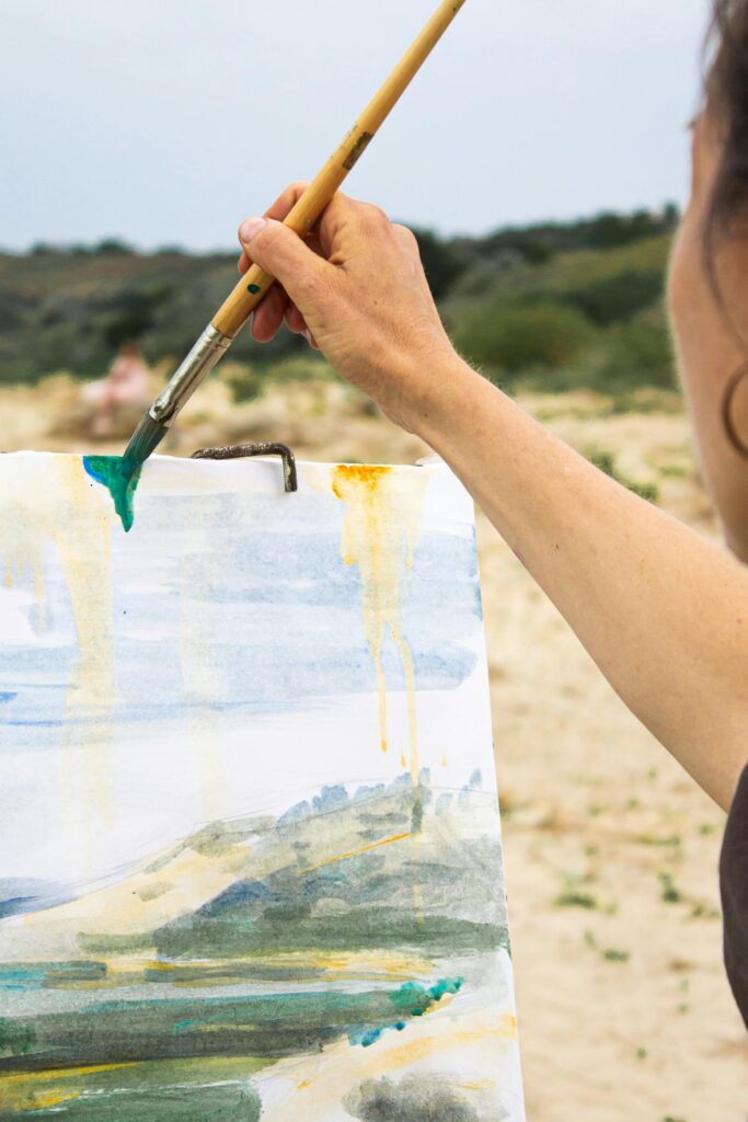 pexels-photo-4729071-4729071 Artist creating watercolor landscape painting outdoors with a focus on creativity.
